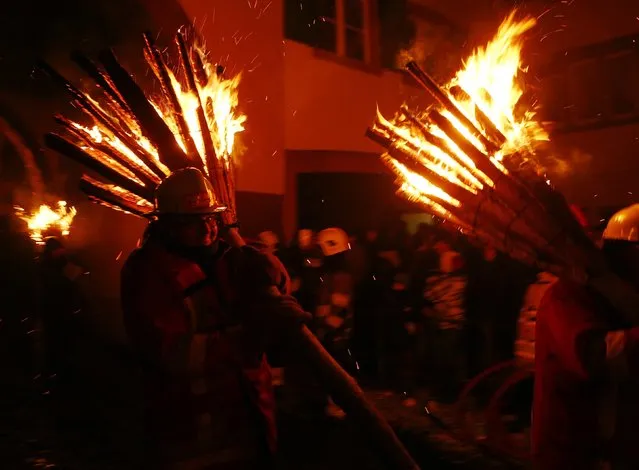 Carnival revellers carry burning wooden sticks as they take part in the traditional Swiss Chienbaese celebration in Liestal near Basel February 22, 2015. (Photo by Ruben Sprich/Reuters)