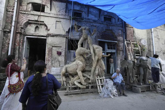 Visitors take pictures as artists prepare idols of Hindu goddess Durga and others at Kumortuli, the potter’s place, in Kolkata, India, Wednesday, September 6, 2023. (Photo by Bikas Das/AP Photo)