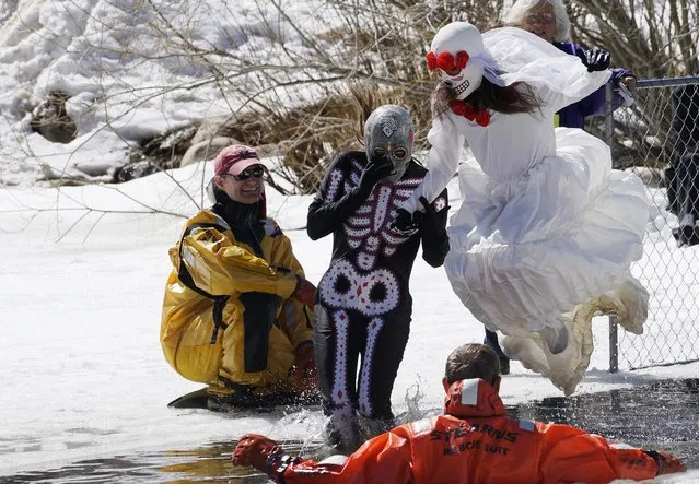 A couple in costumes jumps into a frozen pond as they compete in the Polar Plunge at Frozen Dead Guy Days in Nederland, Colorado March 14, 2015. The winter festival in the small mountain town commemorates the 1994 discovery of the corpse of Bredo Morstol, which is now housed in a shed on dry ice above the town. (Photo by Rick Wilking/Reuters)
