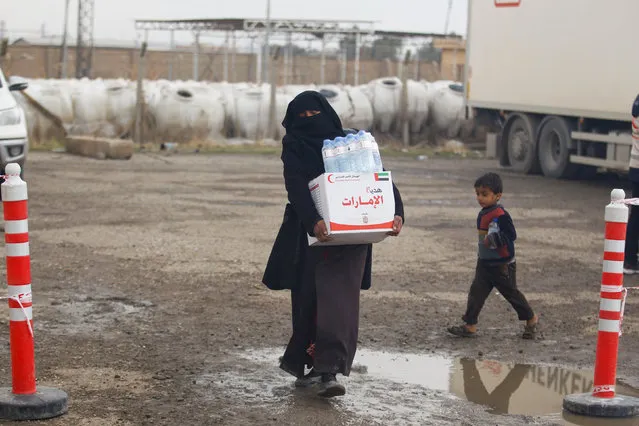 A displaced Iraqi woman, who fled the Islamic State stronghold of Mosul, receives aid in the east of Mosul, Iraq, December 21, 2016. (Photo by Khalid al Mousily/Reuters)