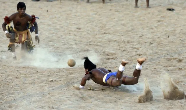 A member of indigenous group Pares dives to head the ball during an exhibition game of soccer where only heads are used to play the game, during the XII Games of the Indigenous People in Cuiaba November 10, 2013. 48 Brazilian Indigenous tribes will present their cultural rituals and compete in traditional sports such as archery, running with logs and canoeing during the XII Games of Indigenous People which will run until November 16. (Photo by Paulo Whitaker/Reuters)