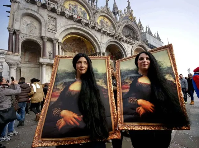 Two carnival revellers masquerade as Leonardo da Vinci's painting “Mona Lisa” pose in St. Mark's Square in Venice, Italy, Sunday, January 31, 2016. Carnival-goers in Venice are being asked by police to momentarily lift their masks as part of new anti-terrorism measures for the annual festivities. (Photo by Domenico Stinellis/AP Photo)