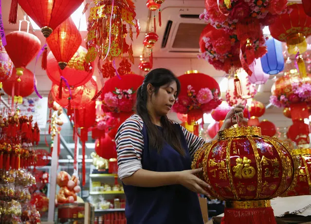 A woman sells lanterns ahead of the Chinese New Year in Kuala Lumpur, Malaysia, February 4, 2016. (Photo by Olivia Harris/Reuters)