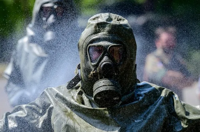 A member of the “ABC-Abwehrregiment 1” of the German Armed Forces (Bundeswehr) undergoes a simulated decontamination procedure at their headquarters in Strausberg, near Berlin, eastern Germany, on July 20, 2022. The Defense Regiment “ABC-Abwehrregiment 1” of the German Armed Forces (Bundeswehr) was officially commissioned on April 6, 2022 to support all military organizational units of the Bundeswehr in the defense against nuclear, biological, chemical threads and industrial hazardous materials and provides decontamination. (Photo by John MacDougall/AFP Photo)