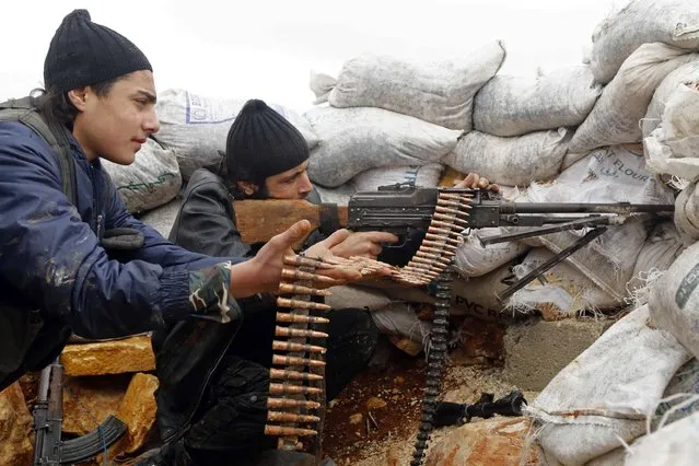 Rebel fighters fire a weapon on the al-Breij frontline, after what they said was an advance by them in the Manasher al-Hajr area where the forces of Syria's President Bashar al-Assad were stationed, in Aleppo January 7, 2015. (Photo by Hosam Katan/Reuters)