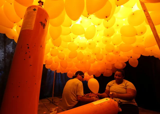 People prepare balloons to be released into the sky as a part of the year-end celebrations in downtown Sao Paulo, Brazil December 30, 2016. (Photo by Paulo Whitaker/Reuters)