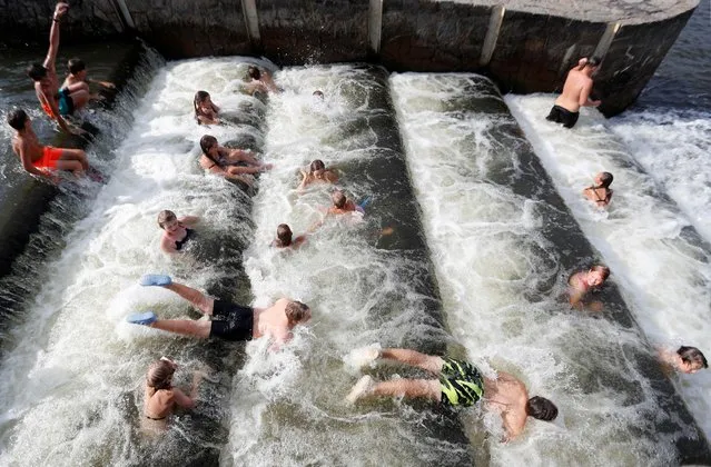 People cool off at a weir of a partially dried-up Berounka river, in Dobrichovice near Prague, Czech Republic on August 17, 2022. (Photo by David W. Cerny/Reuters)