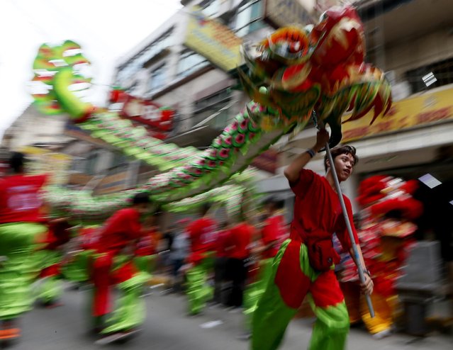 Dragon dancers perform for business establishments on the eve of Chinese Lunar New Year celebrations Sunday, February 7, 2016, in Manila's Chinatown district in the Philippines. (Photo by Bullit Marquez/AP Photo)