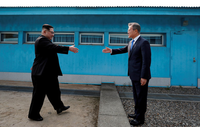 South Korean President Moon Jae-in and North Korean leader Kim Jong Un shake hands at the truce village of Panmunjom inside the demilitarized zone separating the two Koreas, South Korea, April 27, 2018. (Photo by Korea Summit Press Pool via Reuters)