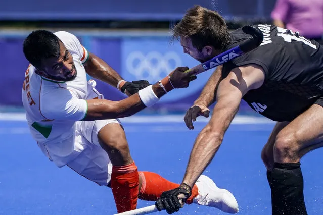 India midfield Manpreet Singh, left, strikes New Zealand defender Nic Woods, right, in the head with his stick on a passing attempt during a men's field hockey match at the 2020 Summer Olympics, Saturday, July 24, 2021, in Tokyo, Japan. (Photo by John Minchillo/AP Photo)