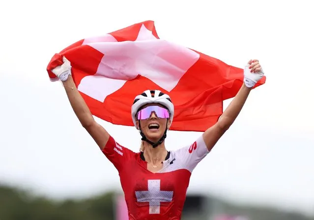 Switzerland's Jolanda Neff celebrates as she approaches the finish line to win the gold medal in the cycling mountain bike women's cross-country race during the Tokyo 2020 Olympic Games at the Izu MTB Course in Izu on July 27, 2021. (Photo by Christian Hartmann/Reuters)