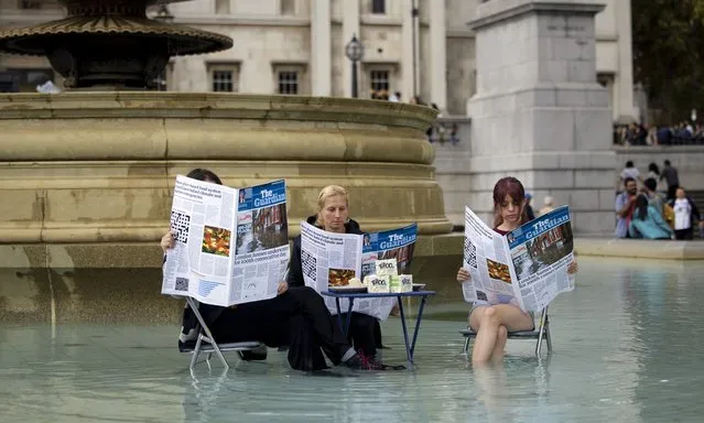 Activists seen reading a fake The Guardian with a table of tofu at the fountain area at Trafalgar Square in Lodon on October 22, 2022. Activists from Animal Rebellion have staged a performance arts at the fountain in Trafalgar Square in response to the “Guardian-reading, tofu-eating wokerati” quote by the former Home Secretary Suella Braverman in the UK Parliament. (Photo by Hesther Ng/SOPA Images/LightRocket via Getty Images)
