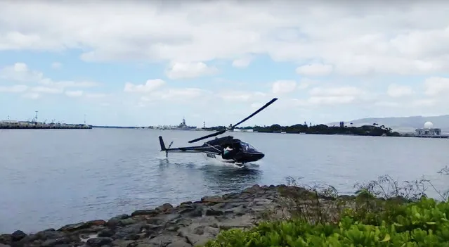 In this image taken from video provided by Shawn Winrich, a helicopter crashes near Parl Harbor, Hawaii on Thursday, February 18, 2016. The private helicopter with five people aboard crashed and sunk into the water, leaving a teenage passenger in critical condition. (Photo by Shawn Winrich/AP Photo)