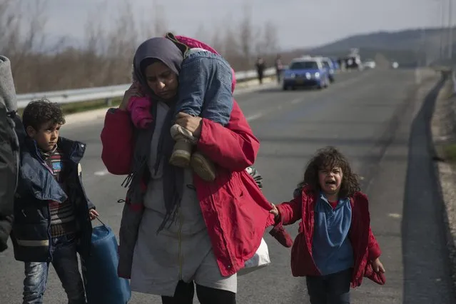 Syrian refugees walk on a motorway in their effort to arrive at the Greek border station of Idomeni on Friday, February 26, 2016. About 4000 people are stranded at the Greek Macedonian border, authorities said. (Photo by Petros Giannakouris/AP Photo)
