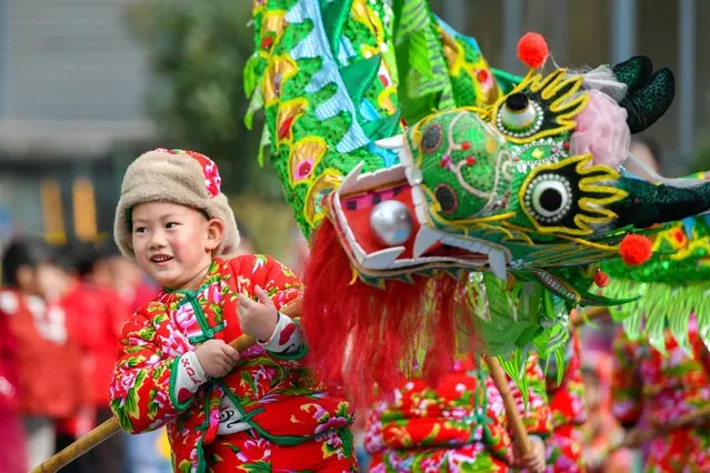 A kindergarten child dressed in a traditional floral printed padded coat performs dragon dance to welcome the upcoming New Year's Day on December 29, 2023 in Changxing County, Huzhou City, Zhejiang Province of China. (Photo by Tan Yunfeng/VCG via Getty Images)