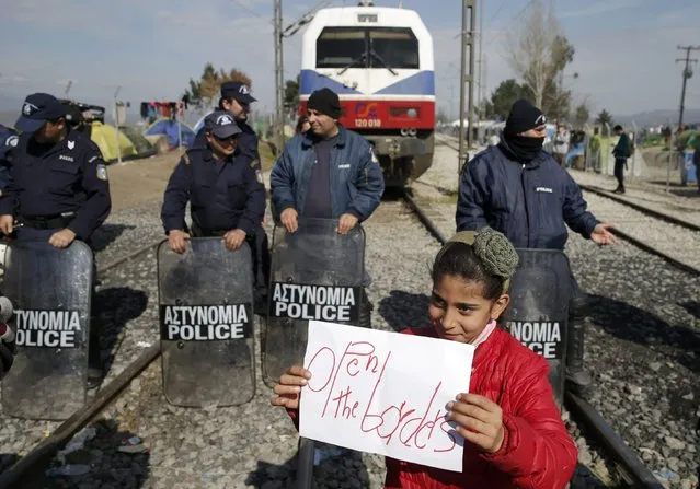 A migrant girl holds a poster during a protest at the Greek-Macedonian border, near the village of Idomeni, Greece March 3, 2016. (Photo by Marko Djurica/Reuters)