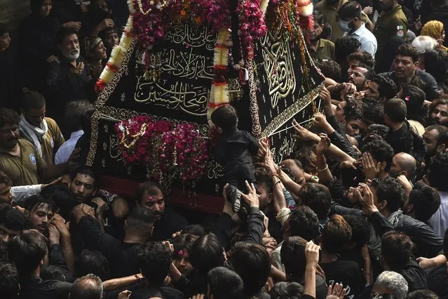 Shiite Muslim devotees take part in a religious procession to mark the 40th day of mourning after the death anniversary of Imam Hussain, the grandson of the Prophet Mohammed, in Lahore on September 28, 2021. (Photo by Arif Ali/AFP Photo)