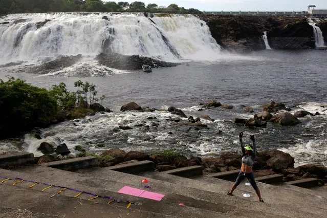 A woman exercises in front of a waterfall at La Llovizna park in Puerto Ordaz in the southern state of Bolivar, Venezuela January 28, 2017. (Photo by Marco Bello/Reuters)