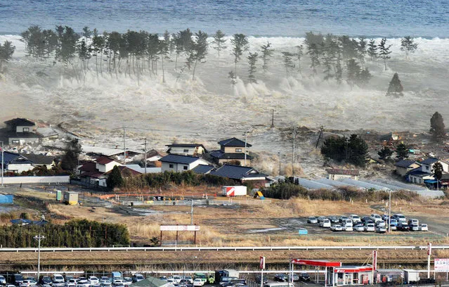 In this March 11, 2011 file aerial photo, waves of tsunami hit the residential area following a powerful earthquake in Natori, Miyagi Prefecture, northeastern Japan. (Kyodo News via AP Photo)