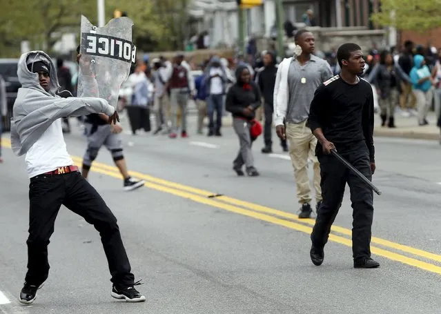 Demonstrators throw rocks at Baltimore police during clashes in Baltimore, Maryland April 27, 2015. Seven Baltimore police officers were injured on Monday as rioters threw bricks and stones and burned patrol cars in violent protests after the funeral of Gray, a black man who died in police custody. (Photo by Shannon Stapleton/Reuters)