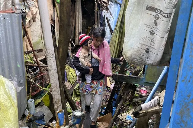 Residents walk past damages caused by an earthquake as they evacuate to safer grounds at Hinatuan town, Surigao del Sur province, southern Philippines on Sunday December 3, 2023. A powerful earthquake struck Saturday off the southern Philippine coast, prompting many villagers to flee their homes in panic around midnight after Philippine authorities issued a tsunami warning. (Photo by Ivy Marie Mangadlao/AP Photo)
