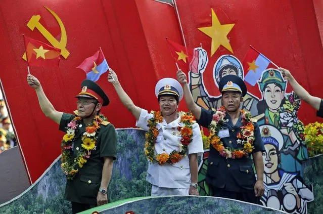 Vietnamese military personnel wave flags during a parade celebrating the 40th anniversary of the end of the Vietnam War which is also remembered as the “Fall of Saigon”, in Ho Chi Minh City, Vietnam, Thursday, April 30, 2015. (Photo by Dita Alangkara/AP Photo)