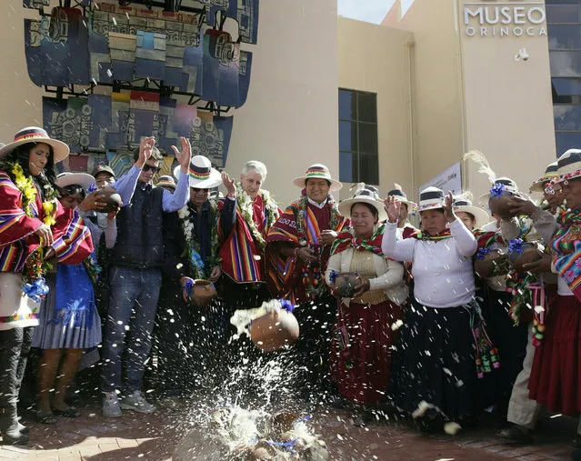 Bolivia's President Evo Morales (C) with government and local authorities throws liquid-filled pots as part of a ceremony inaugurating the Orinoca Museum in Orinoca, Bolivia February 2, 2017. (Photo by David Mercado/Reuters)