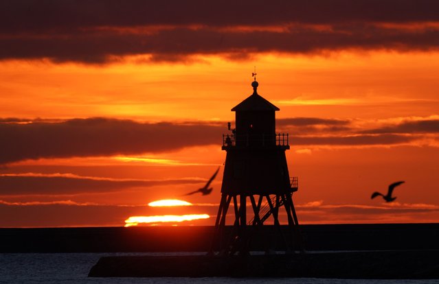 Sunrise at the Herd Groyne lighthouse in South Shields on the North East coast on the Autumn Equinox, United Kingdom on September 22, 2021, 2021. (Photo by Owen Humphreys/PA Images via Getty Images)