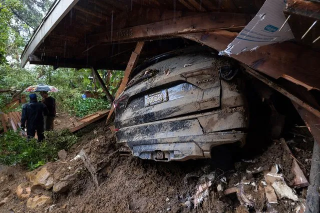 A car remains in the wreckage after a house and garage were destroyed by a landslide as a historic atmospheric river storm inundates the Hollywood Hills area of Los Angeles, California, on February 6, 2024. A powerful storm lashing California has left at least three people dead and caused devastating mudslides and flooding, after dumping months' worth of rain in a single day. (Photo by David McNew/AFP Photo)