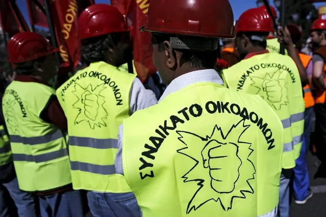 Protesters from the Communist-affiliated trade union PAME hold red flags during a May Day rally in Athens May 1, 2015. The words on the vest read: “Construction workers syndicate”. (Photo by Alkis Konstantinidis/Reuters)