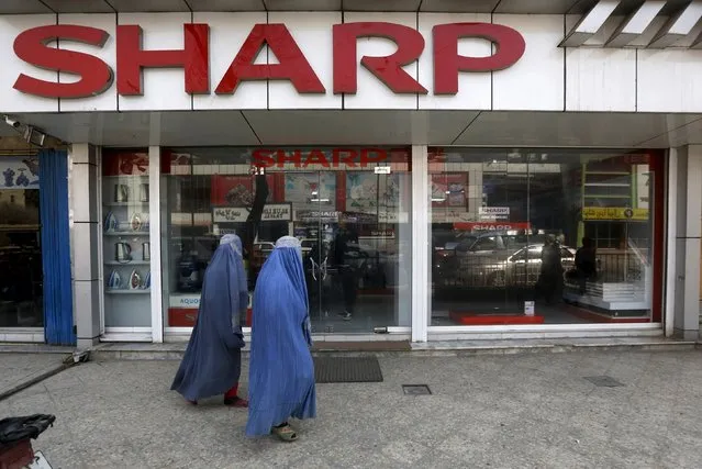 Afghan women wearing burqas walk past a “SHARP” store in Kabul, Afghanistan, February 18, 2016. (Photo by Omar Sobhani/Reuters)