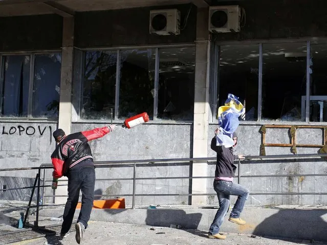 Protesters hurl items at a government building in Tuzla, February 7, 2014. (Photo by Dado Ruvic/Reuters)