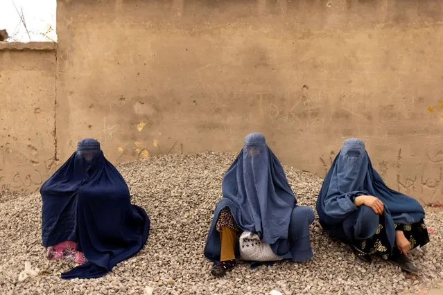 Women wearing burqas pause at the side of a road in Kabul, Afghanistan on October 26, 2021. (Photo by Jorge Silva/Reuters)