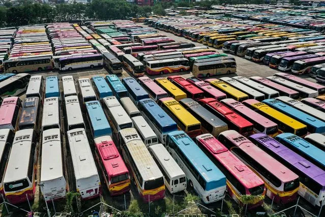 This aerial picture shows tour buses stored in a parking lot in Hong Kong on November 1, 2021, as strict Covid-19 measures keep tourists away from the city impacting the tourism sector. (Photo by Isaac Lawrence/AFP Photo)