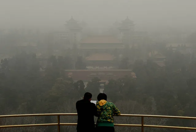 Tourists visit Jingshan Hill before the Forbidden City as heavy air pollution continues to shroud Beijing on February 26, 2014. Beijing's official reading for PM 2.5, small airborne particles which easily penetrate the lungs and have been linked to hundreds of thousands of premature deaths, stood at 501 micrograms per cubic metre. (Photo by Mark Ralston/AFP Photo)
