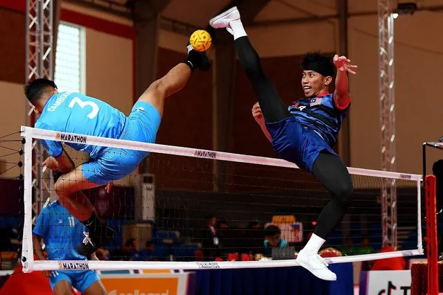 Malaysia's Muhammad Hafizul Adnan (R) vies for the ball with Cambodia's Phom Kongkia (L) during their mens sepaktakraw team regu match at the 32nd Southeast Asian Games (SEA Games) in Phnom Penh on May 12, 2023. (Photo by Nhac Nguyen/AFP Photo)