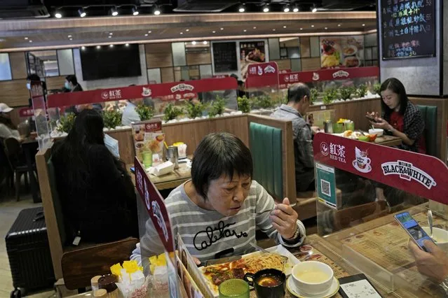 Customers have lunch in a restaurant in Hong Kong, Monday, November 29, 2021. The new omicron variant was found in Hong Kong, Belgium and Tel Aviv. The European Union, the United States and Britain imposed curbs on travel from Africa. Israel banned entry by foreigners. (Photo by Kin Cheung/AP Photo)