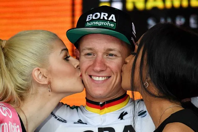Germany's Pascal Ackermann receives the kiss of the race's hostesses as he stands on the podium after winning the the 2nd stage of the Giro d'Italia, tour of Italy cycling race, from Bologna to Fucecchio, Sunday, May 12, 2019. (Photo by Alessandro Di Meo/ANSA via AP Photo)