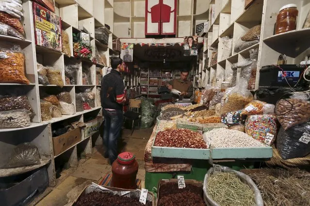 A herbs and nuts vendor works inside his shop in Qamishli, Syria April 11, 2016. (Photo by Rodi Said/Reuters)