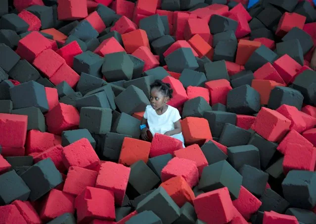 A child is surrounded by sponge cushions as she plays at a Johannesburg shopping mall Friday, December 17, 2021. (Photo by Denis Farrell/AP Photo)