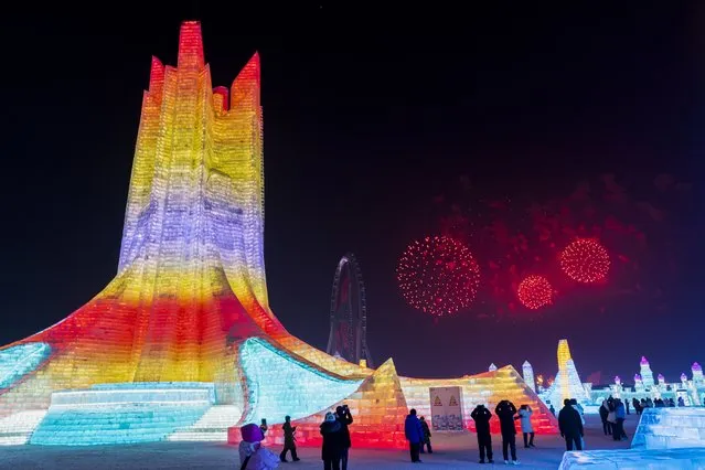 In this photo released by Xinhua News Agency, Visitors watch fireworks explode during a ceremony on the opening night of the Harbin International Ice and Snow Festival in Harbin in northeastern China's Heilongjiang Province, Thursday, January 5, 2023. The Harbin International Ice and Snow Festival is known for massive, elaborate, and colorfully lit ice sculptures featuring animals, cartoon characters, and various landmarks. (Photo by Xie Jianfei/Xinhua via AP Photo)
