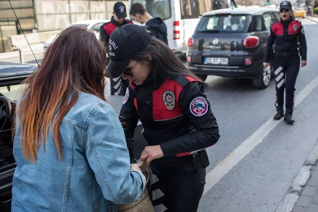 A female police officer from Istanbul's Motorcycled Police Unit searches a driver during a roadside checkpoint operation on March 7, 2017 in Istanbul, Turkey. (Photo by Chris McGrath/Getty Images)