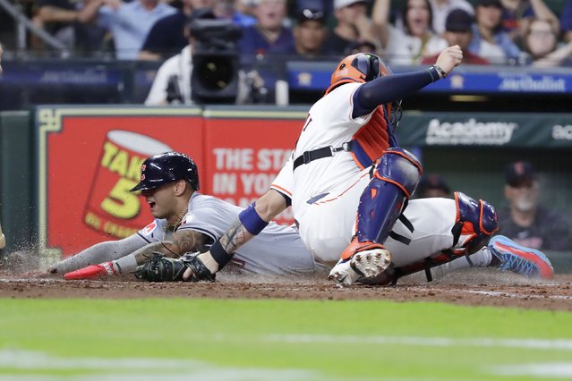 Cleveland Guardians' Brayan Rocchio, left, is safe on his slide into home plate on the RBI triple by Steven Kwan as Houston Astros catcher Victor Caratini, right, attempts the tag during the fifth inning of a baseball game Wednesday, May 1, 2024, in Houston. (Photo by Michael Wyke/AP Photo)