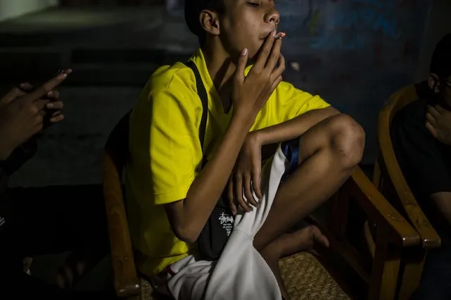 Aqsan (15), smokes at a coffee shop with his friends on March 7, 2017 in Yogyakarta, Indonesia. (Photo by Ulet Ifansasti/Getty Images)