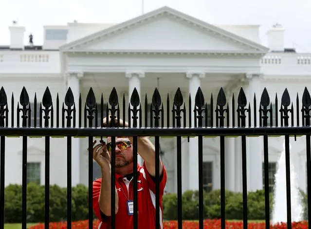 A U.S. government contractor begins the initial installation of security spikes on the existing White House perimeter fence in Washington, United States, July 1, 2015. (Photo by Gary Cameron/Reuters)