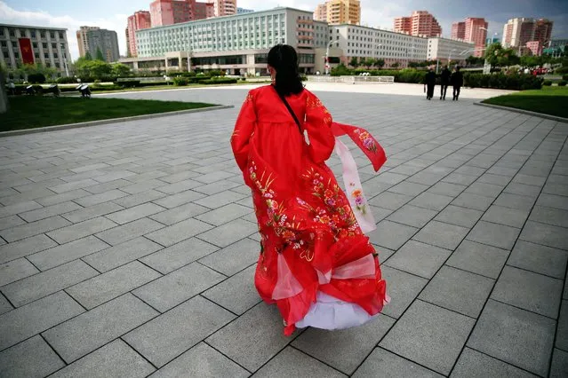 A guide wearing a traditional dress walks in front of visitors at the Arch of Triumph in Pyongyang, North Korea May 4, 2016. (Photo by Damir Sagolj/Reuters)