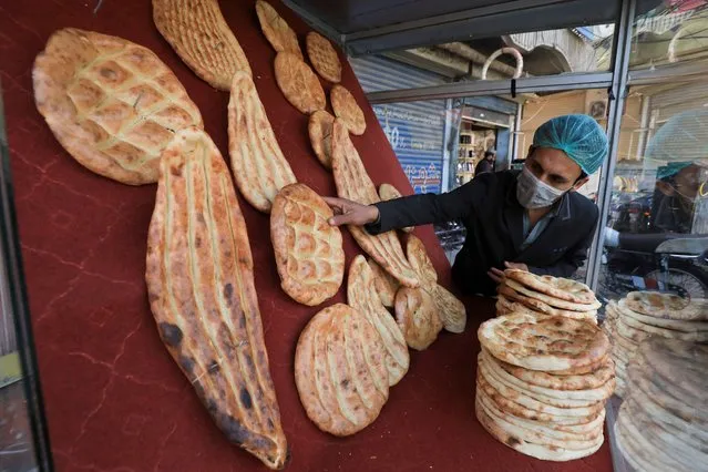 A man arranges naans, some traditional bread, after they were baked in an oven, to sell from a stall in Peshawar, Pakistan, February 7, 2022. (Photo by Fayaz Aziz/Reuters)