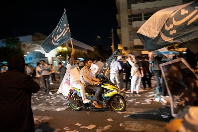 A supporter of Masoud Pezeshkian, a candidate for the June 28 presidential election, holds symbols of his election during a Streetly campaign gathering in Tehran, Iran, Wednesday, June 26, 2024. (Photo by Sobhan Farajvan/Pacific Press/Rex Features/Shutterstock)