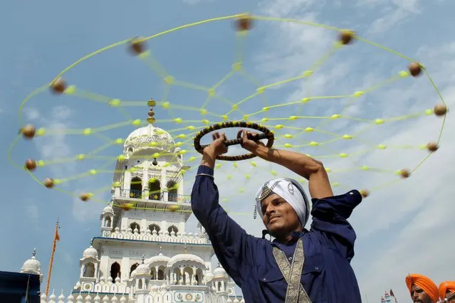 An Indian Nihang – religious Sikh warrior – shows off his skills in the Sikh martial art known as “Gatka” during a procession from the Sikh Shrine Gurudwara Lohgarh Sahib to Gurudwara San Sahib at village Basarke, about 13 kms from Amritsar on May 23, 2014, on the occasion of the 535th birth anniversary of Guru Amardas, the third master of the Sikhs. Guru Amardas lived from May 5, 1479 to September 1,1574 and was the third of the 10 Gurus of Sikhism and was given the title of Sikh Guru on March 26, 1552. (Photo by Narinder Nanu/AFP Photo)