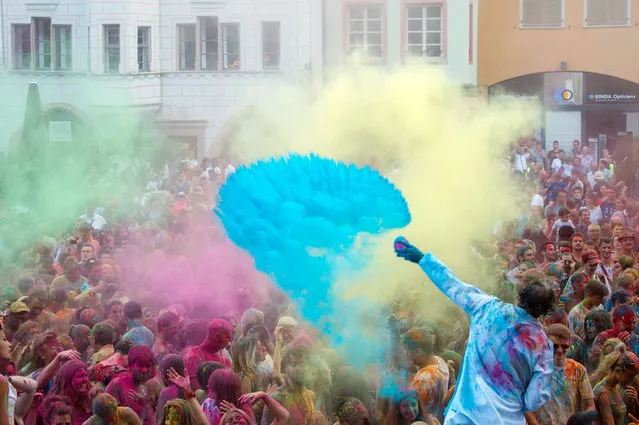 People take part in a colour battle organised by the Artonik company during a street theater festival in Mulhouse on July 18, 2015. (Photo by Sebastien Bozon/AFP Photo)